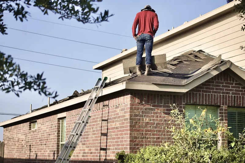 Professional roofer working on a residential roof in Whitackers Court